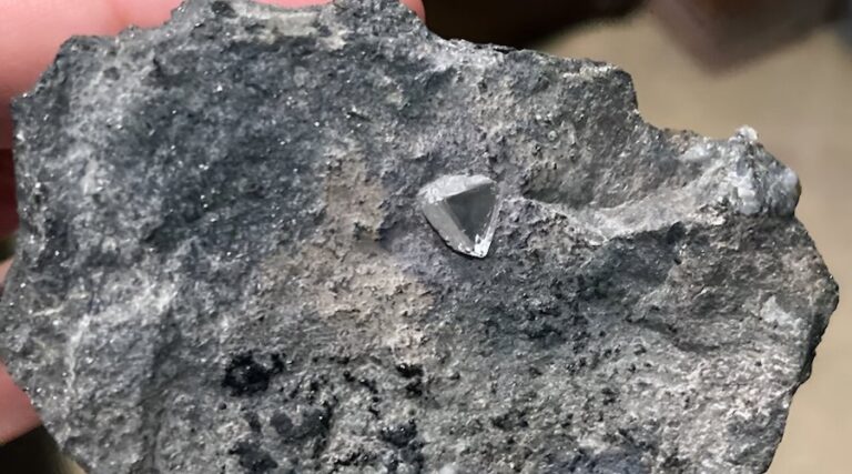 A diamond sticking out of a piece of kimberlite rock