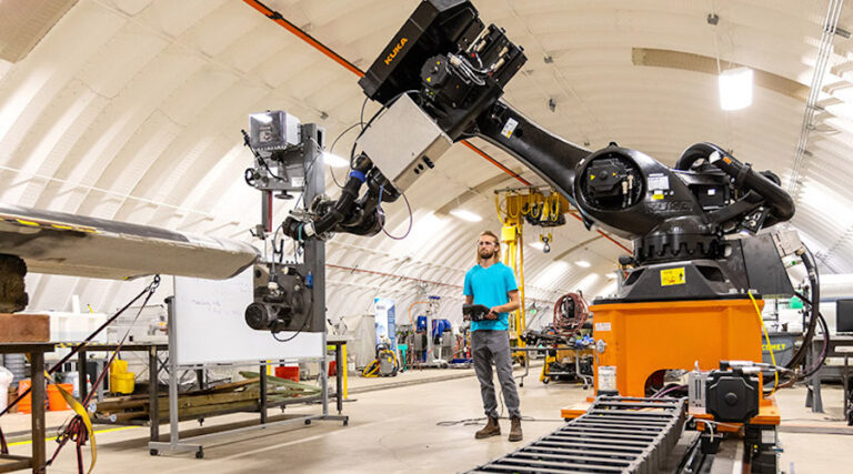 Hunter Huth has been programing a robotic arm to perform the finishing work on wind turbine blades at the facility.